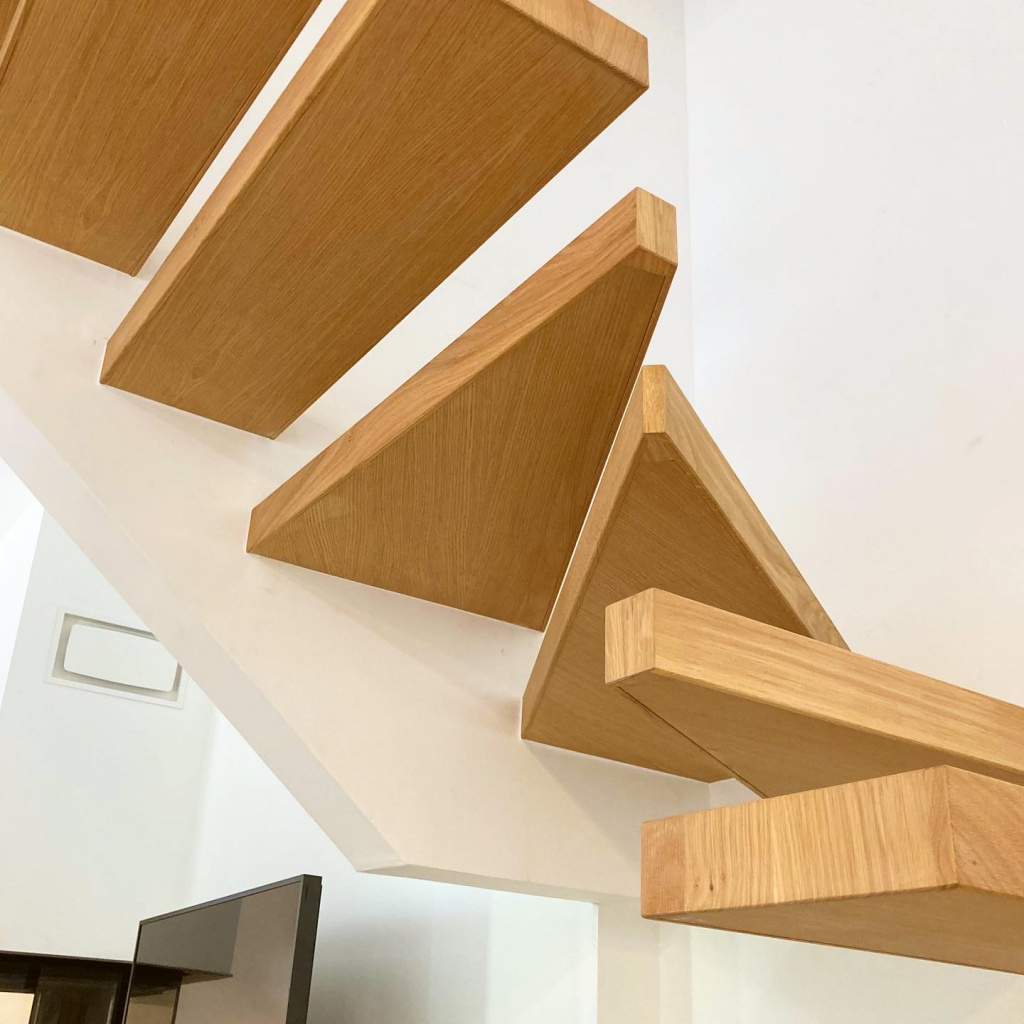 Escalier suspendu en bois clair dans une maison moderne à Toulouse, par ARTEF menuiserie